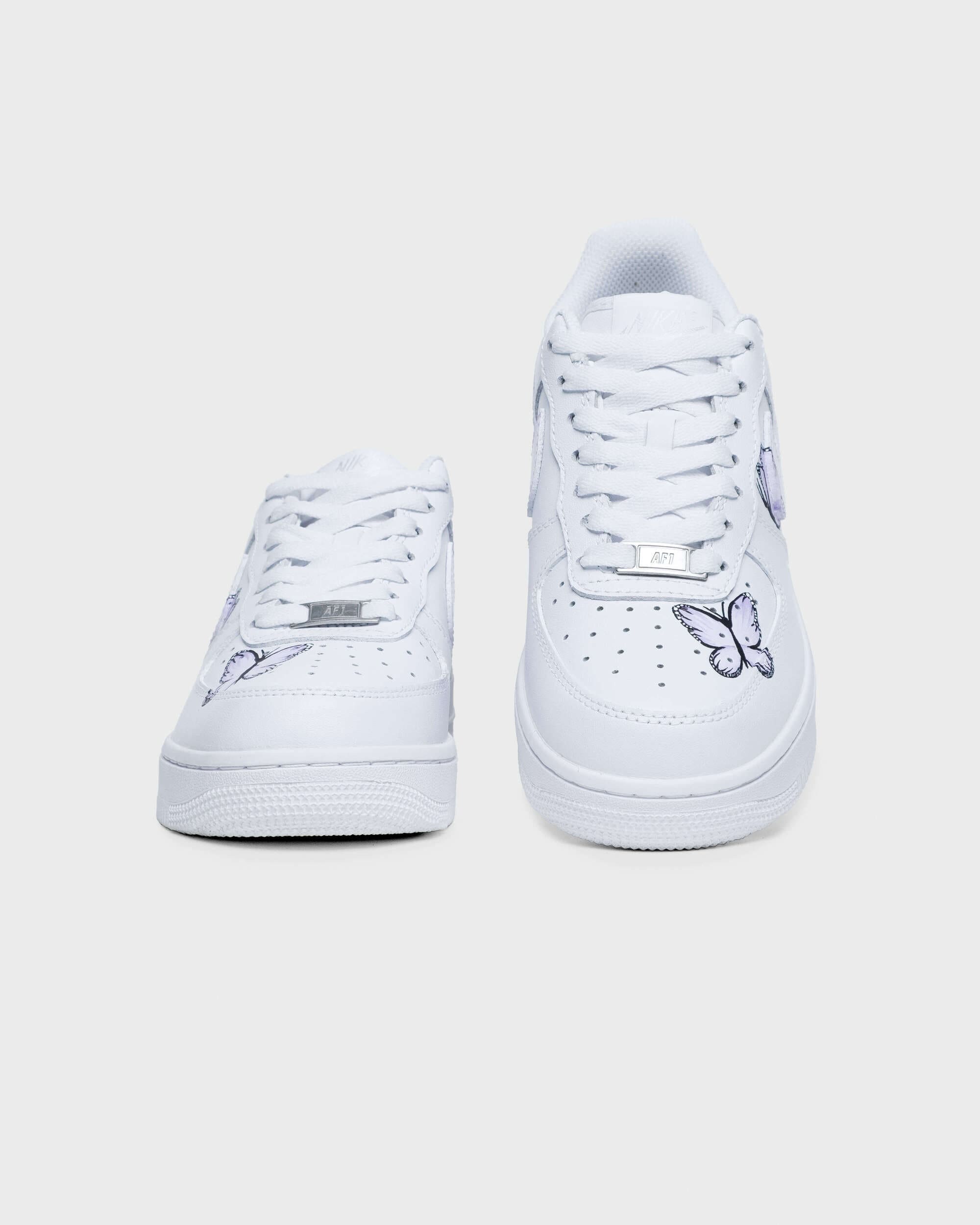 Front view of hand-painted custom Air Force 1 sneakers featuring purple butterfly details on a white base
