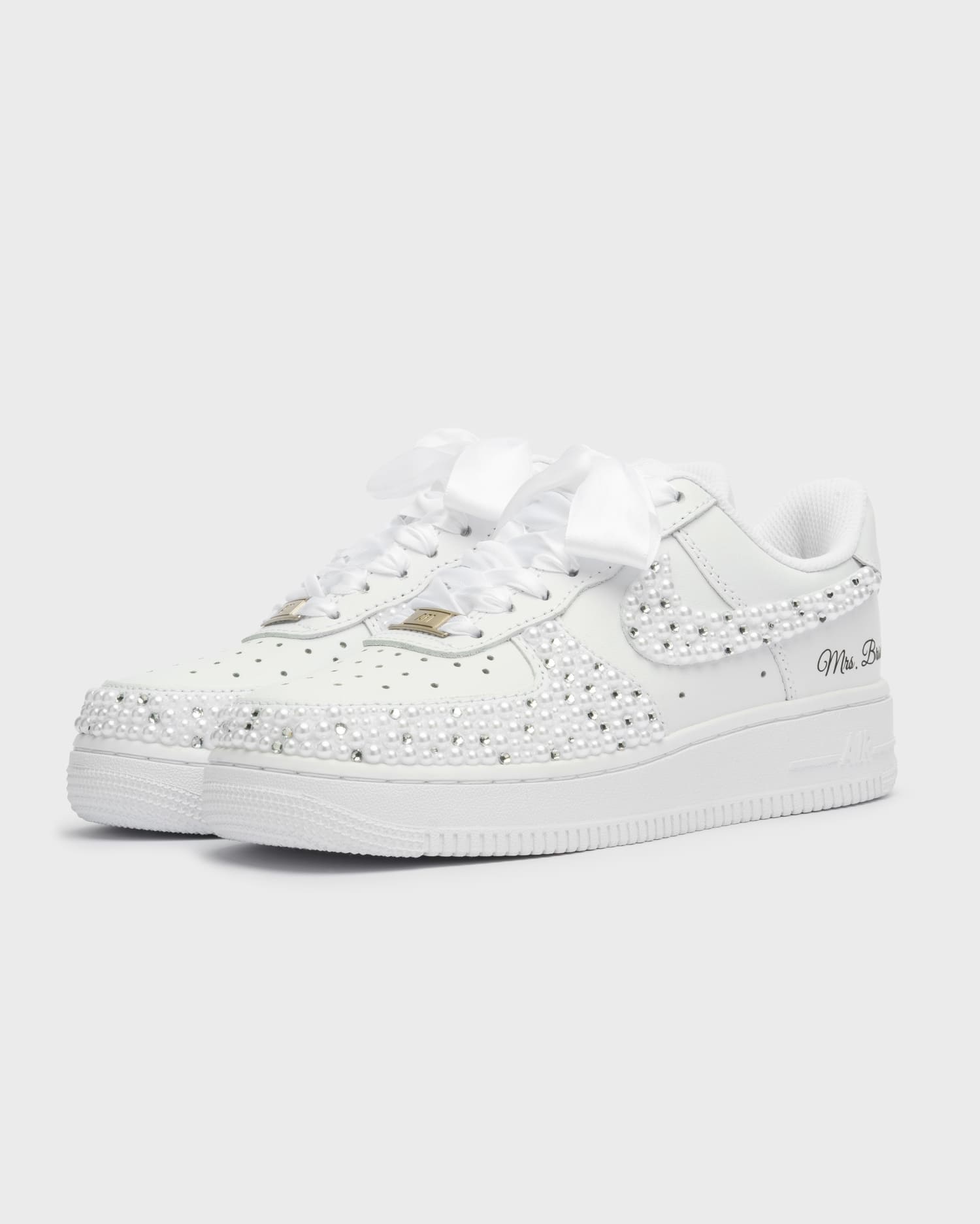 Custom white Air Force 1 wedding sneakers fully adorned with pearls. Handcrafted bridal shoes with satin laces and personalized 'Mrs. Bride' embroidery. Elegant and unique wedding footwear for brides.