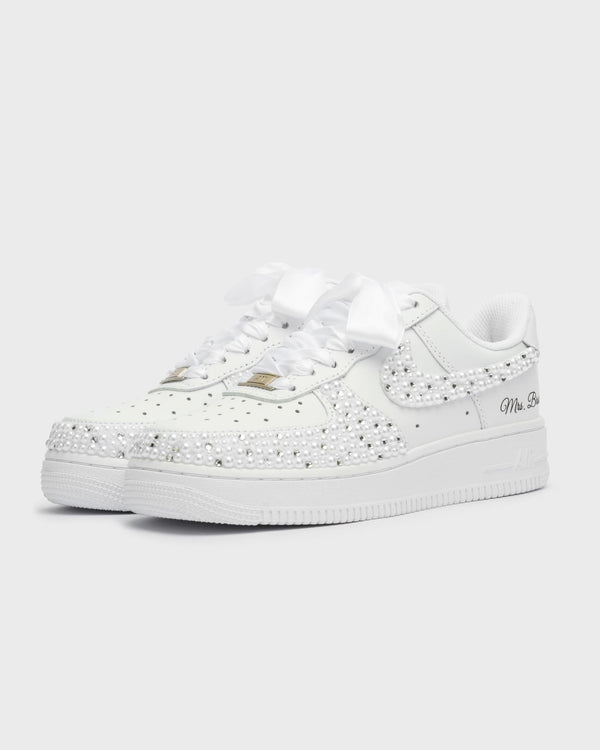 Custom white Air Force 1 wedding sneakers fully adorned with pearls. Handcrafted bridal shoes with satin laces and personalized 'Mrs. Bride' embroidery. Elegant and unique wedding footwear for brides.