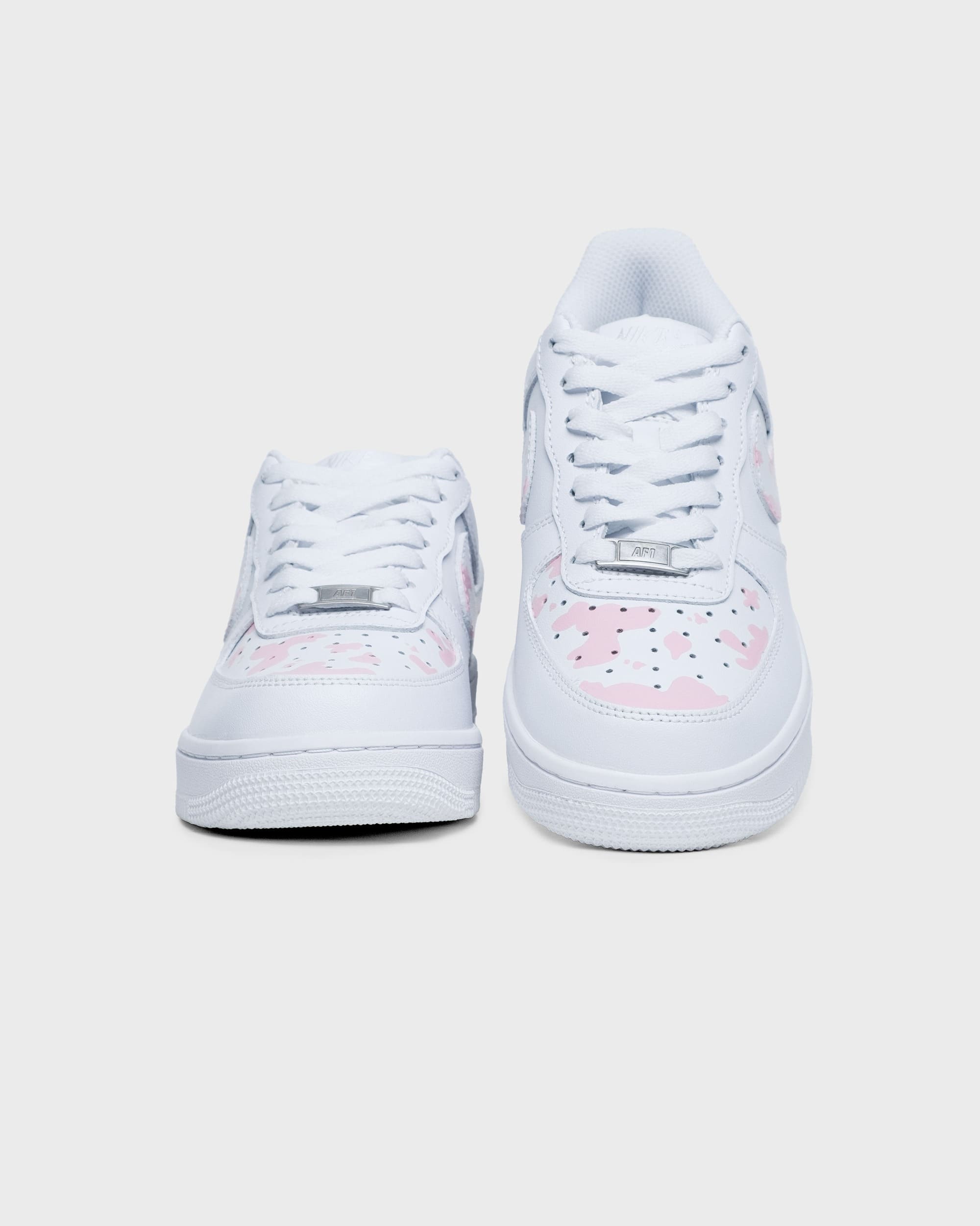 Front view of custom pink cow print Air Force 1 sneakers with unique artwork.