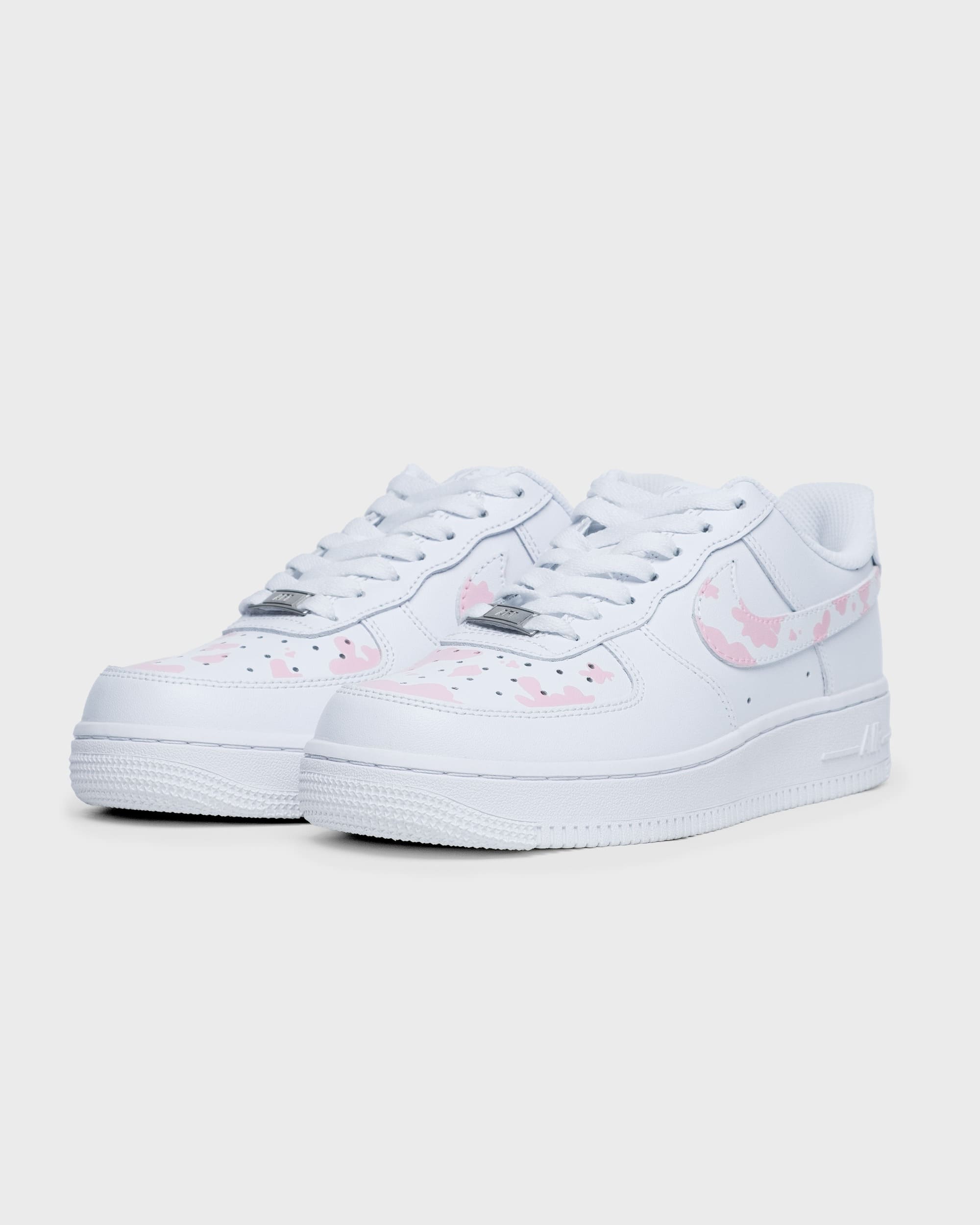 Side angle of custom pink cow print Nike Air Force 1 shoes with personalized details.