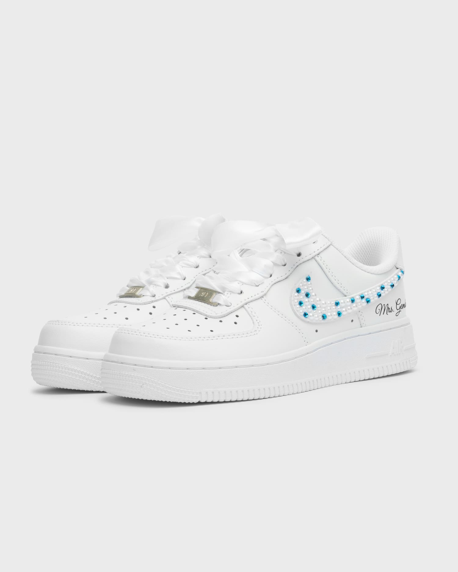 Custom white Air Force 1 wedding sneakers with white and blue pearl details. Handcrafted bridal shoes with satin laces and personalized embroidery. Elegant and unique custom sneakers for a bride.