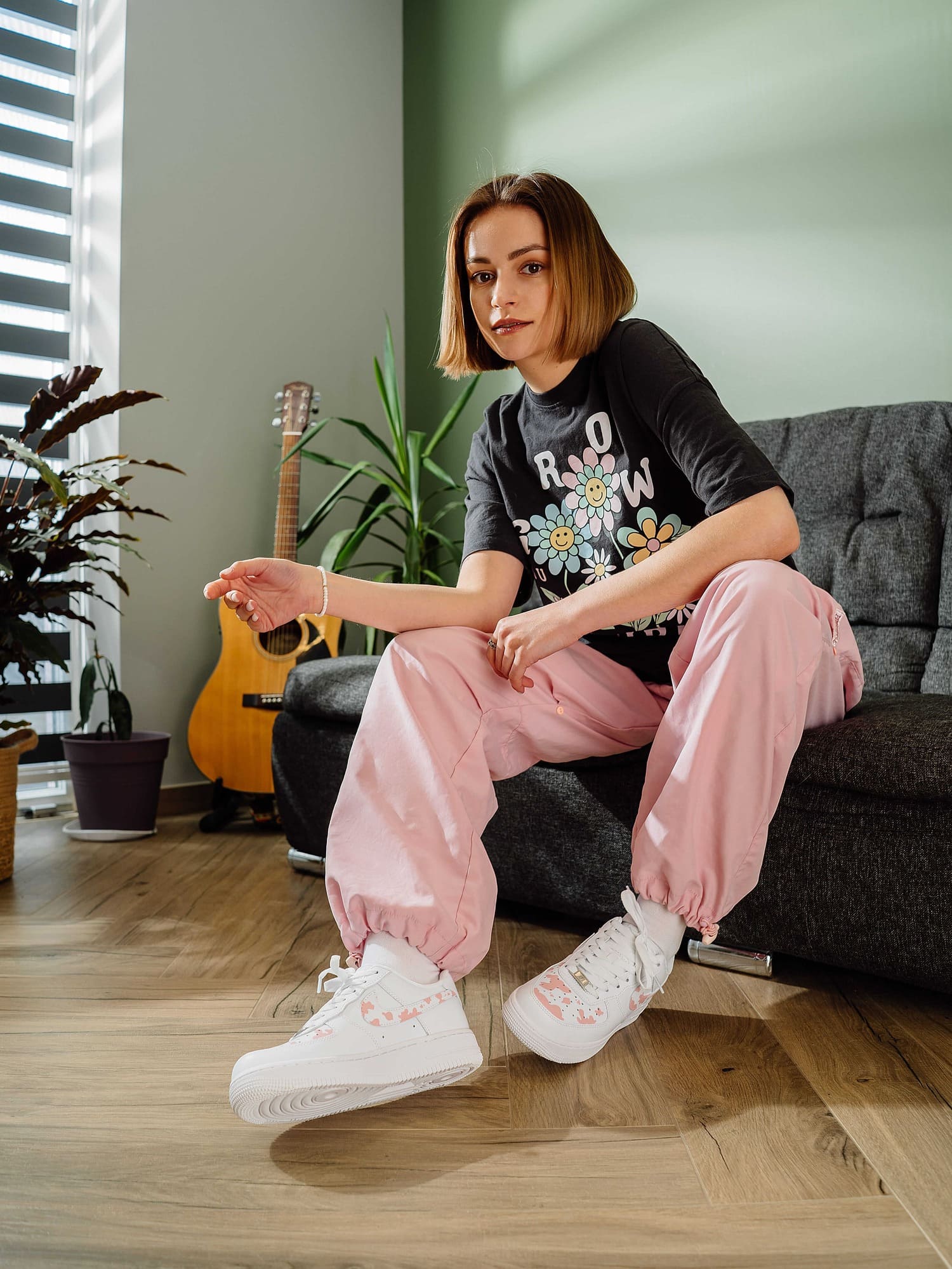 Model wearing pink cow print custom Air Force 1 sneakers with casual style.