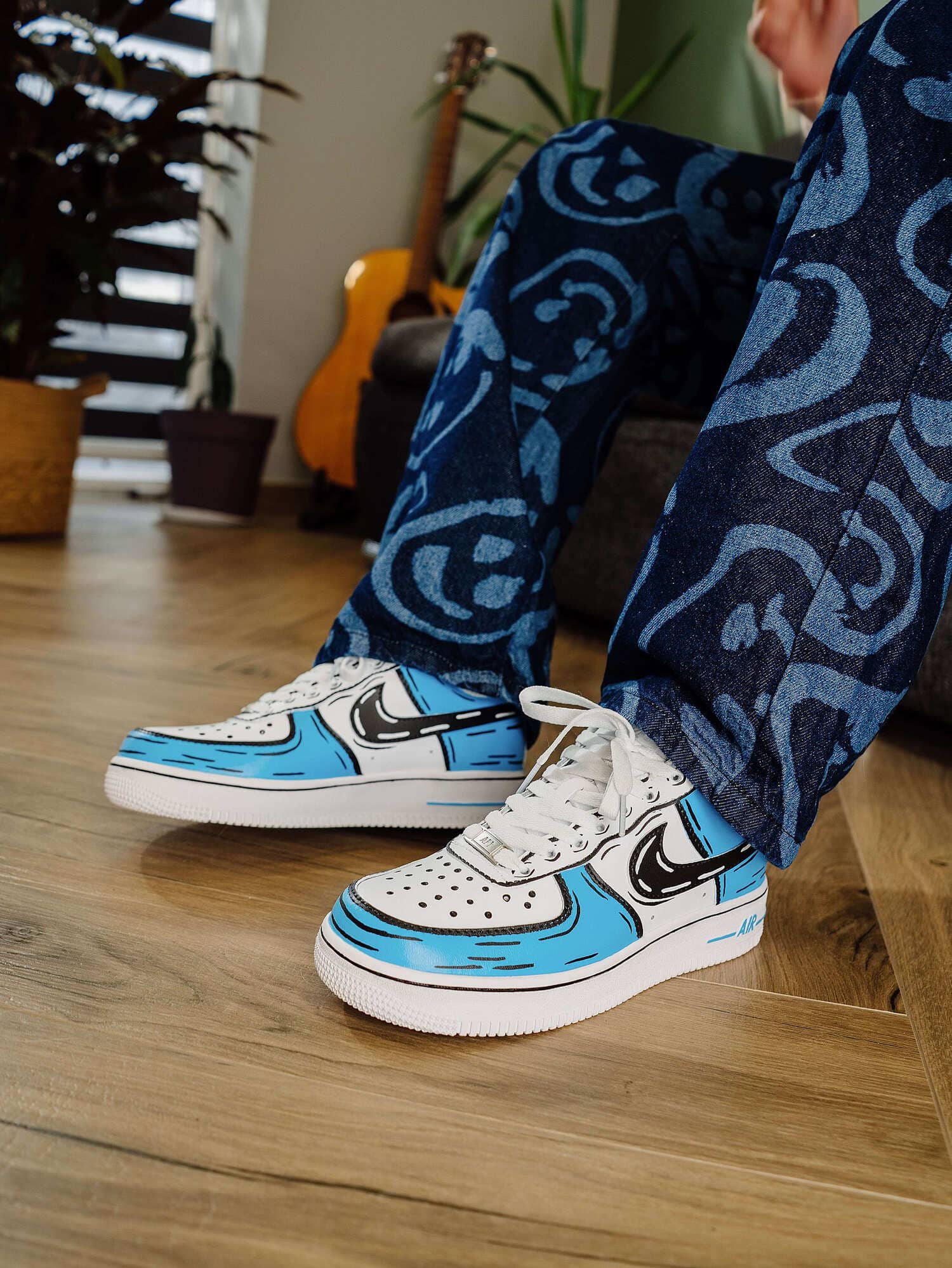 Close-up of cartoon-style blue custom Air Force 1 sneakers on model, highlighting the unique hand-painted design.