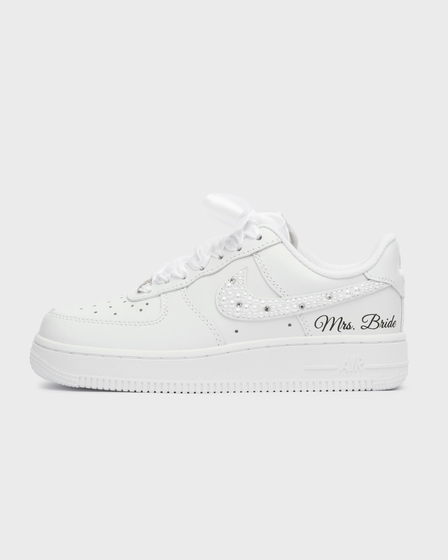 White Air Force 1 custom bridal sneakers with pearl decorations on the swoosh and 'Mrs. Bride' personalization. Handmade wedding shoes with satin laces, perfect for a stylish bride.