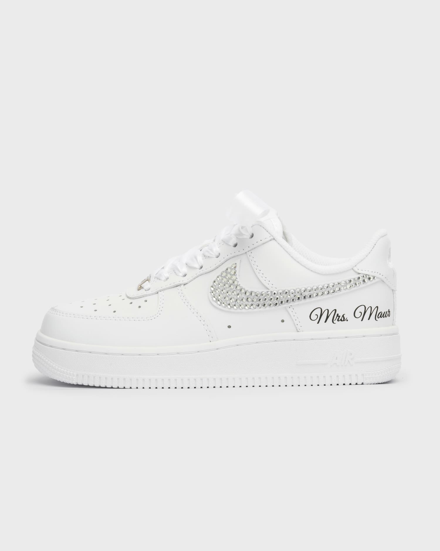White Air Force 1 custom bridal sneakers with sparkling rhinestone swoosh and 'Mrs. Maur' embroidery. Personalized wedding shoes with satin laces, ideal for brides looking for unique and elegant footwear."
