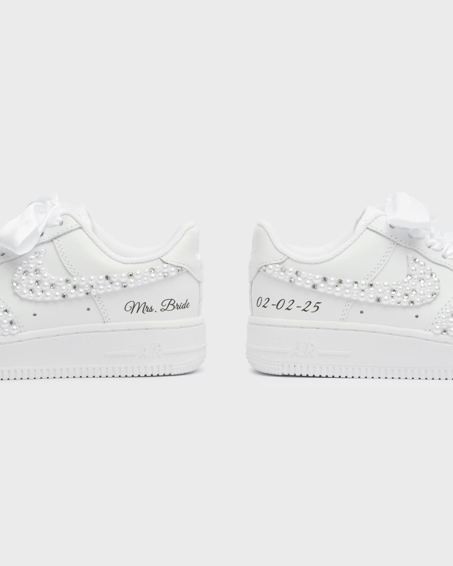 Personalized white Air Force 1 wedding sneakers with pearl embellishments, 'Mrs. Bride' embroidery, and custom wedding date '02-02-25'. Elegant handcrafted bridal sneakers for a unique wedding style.