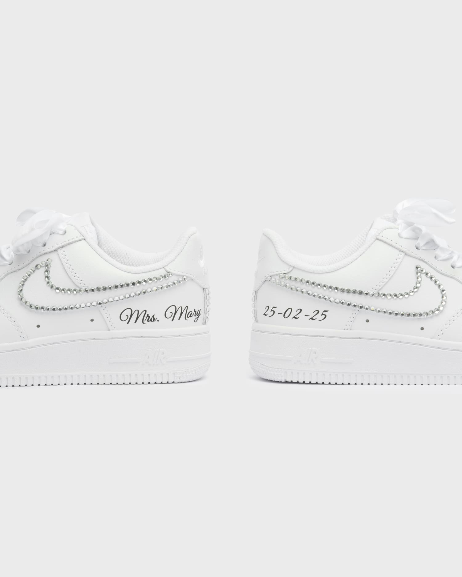 Personalized white Air Force 1 wedding sneakers with rhinestone details, 'Mrs. Mary' embroidery, and custom wedding date '25-02-25'. Elegant handcrafted bridal sneakers for a unique wedding look.