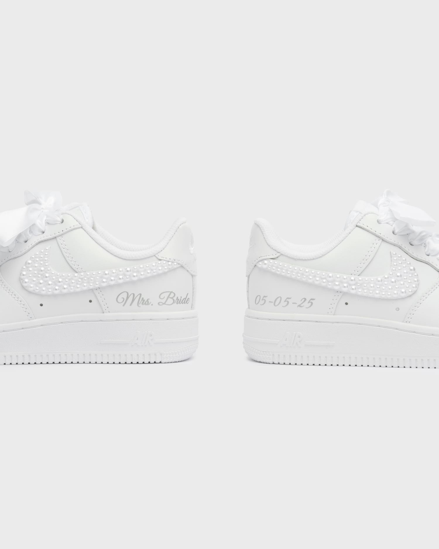 Personalized white Air Force 1 wedding sneakers with pearl swoosh, 'Mrs. Bride' embroidery, and custom wedding date '05-05-25'. Elegant handcrafted bridal sneakers for a stylish wedding day.