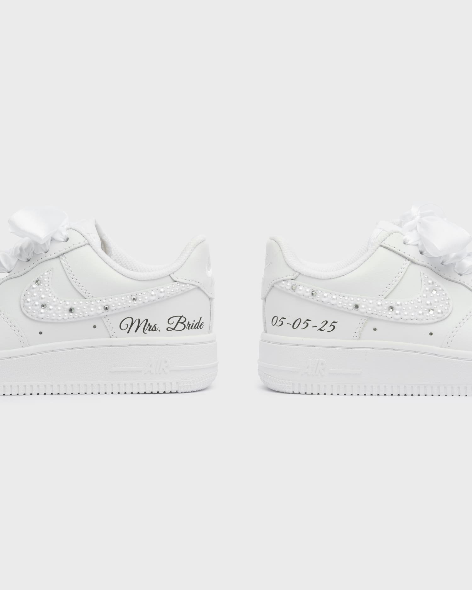 Personalized white Air Force 1 wedding sneakers with pearl swoosh, 'Mrs. Bride' embroidery, and custom wedding date '05-05-25'. Elegant bridal sneakers for a unique wedding look.