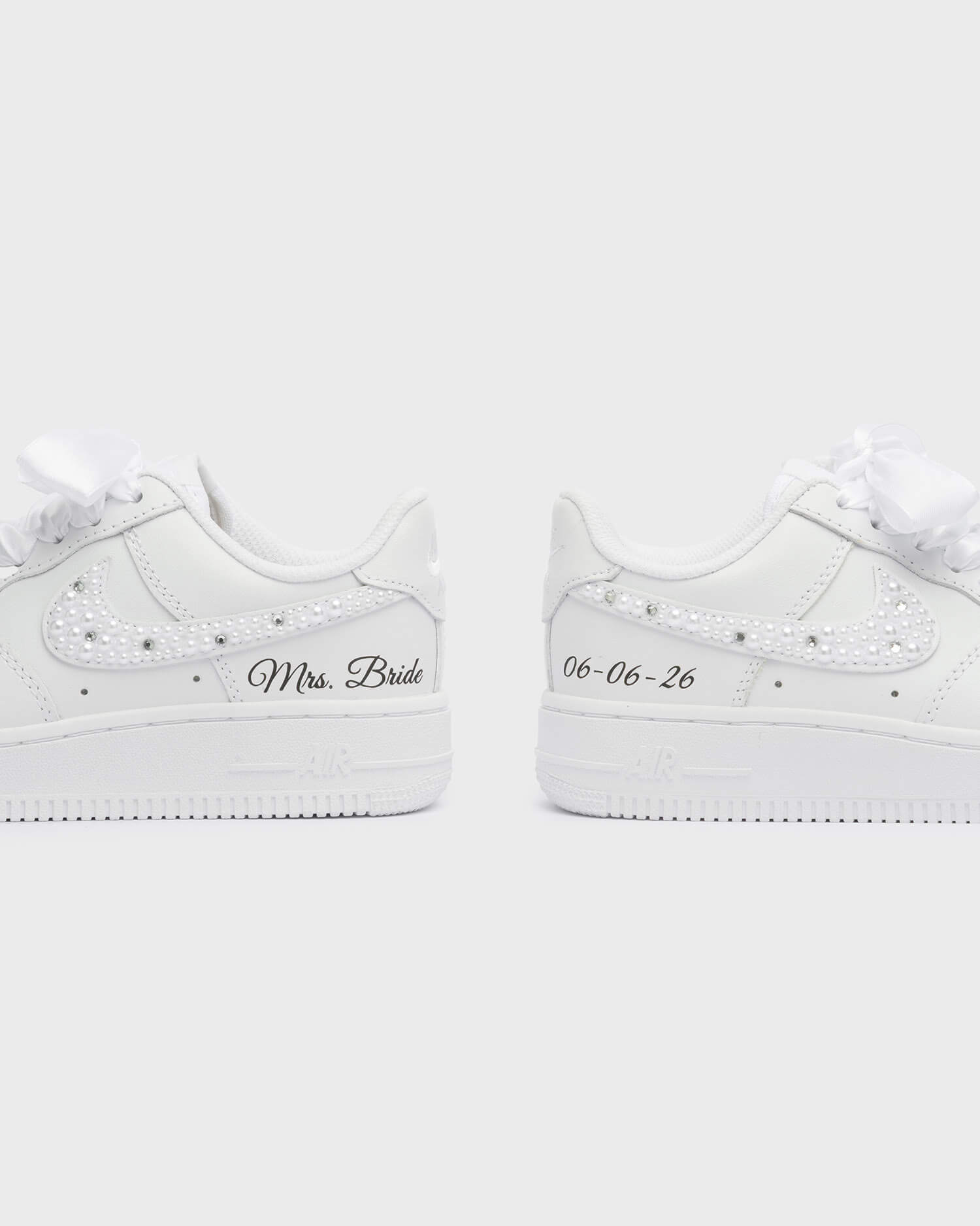 Personalized white Air Force 1 wedding sneakers with pearl swoosh, 'Mrs. Bride' embroidery, and custom wedding date '05-05-25'. Elegant bridal sneakers for a unique wedding look.
