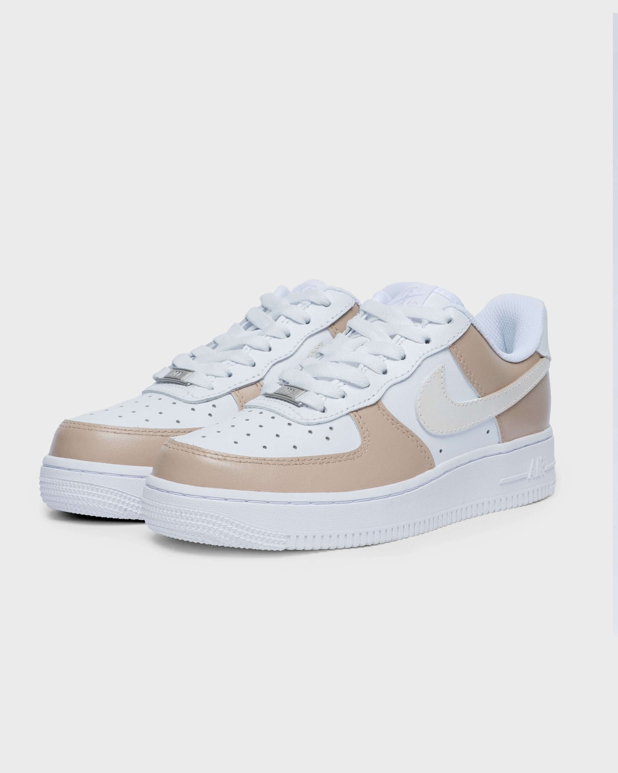 Close-up of hand-painted custom Air Force 1 sneakers in cream tones, featuring a minimalist and stylish design.