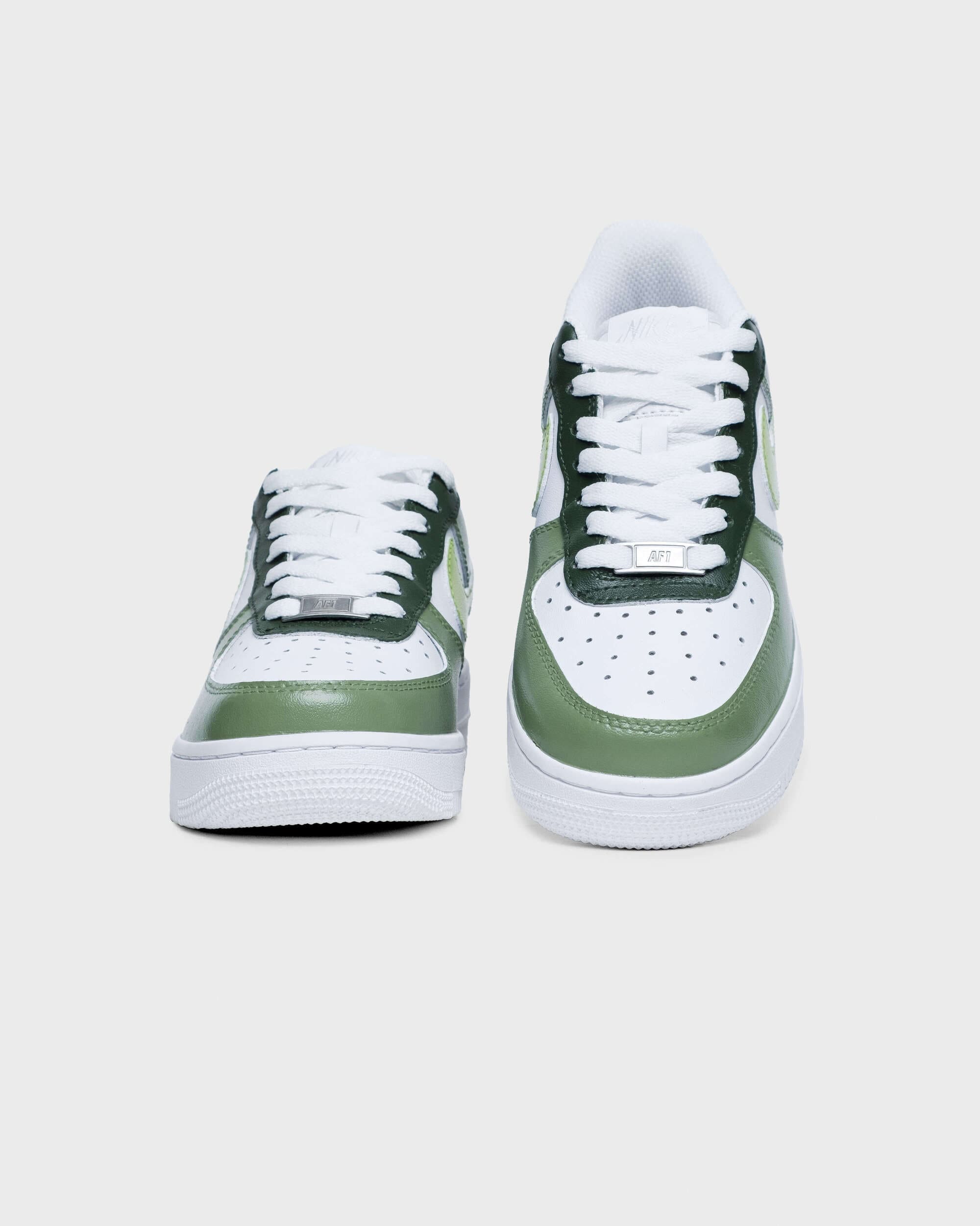 Front view of Nike Air Force 1 sneakers in green with lime swoosh, showcasing the toe area.