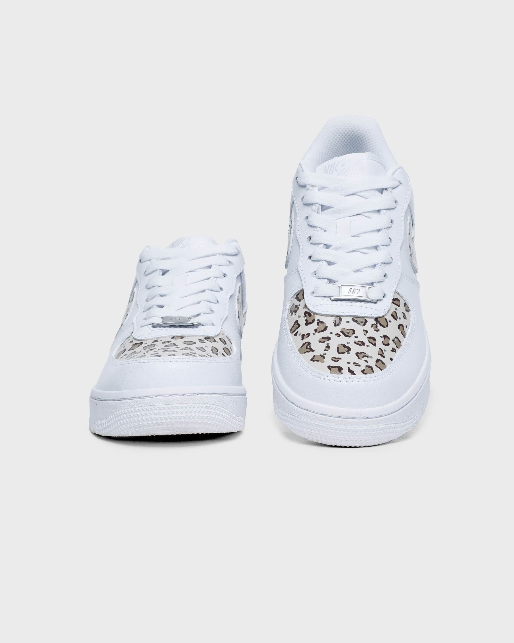 Front view of custom Air Force 1 sneakers featuring leopard print accents on the toe box and swoosh, paired with white laces for a stylish, standout look.