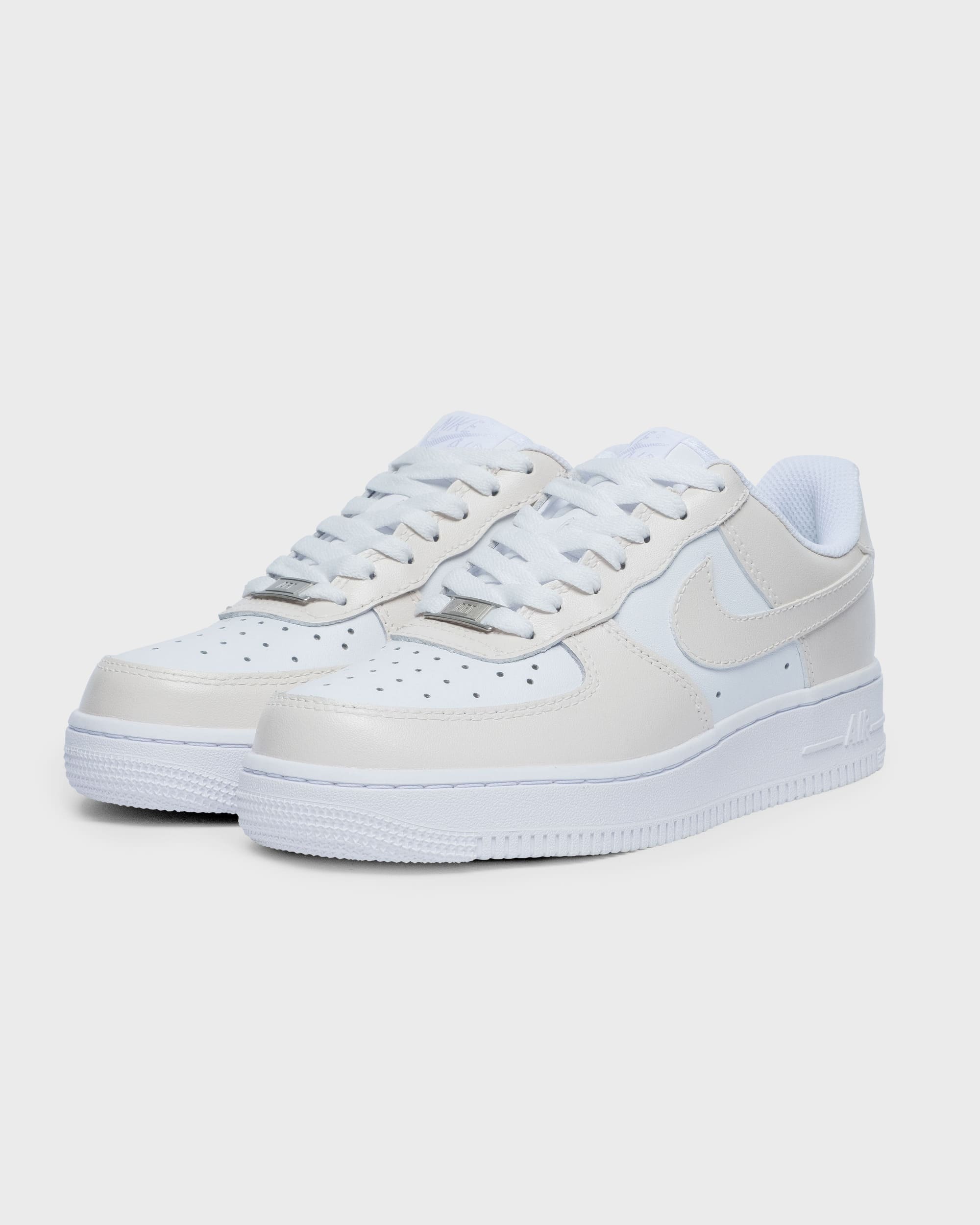 Angled view of custom Air Force 1 sneakers with a minimalist cream design, ideal for a unique yet subtle style.