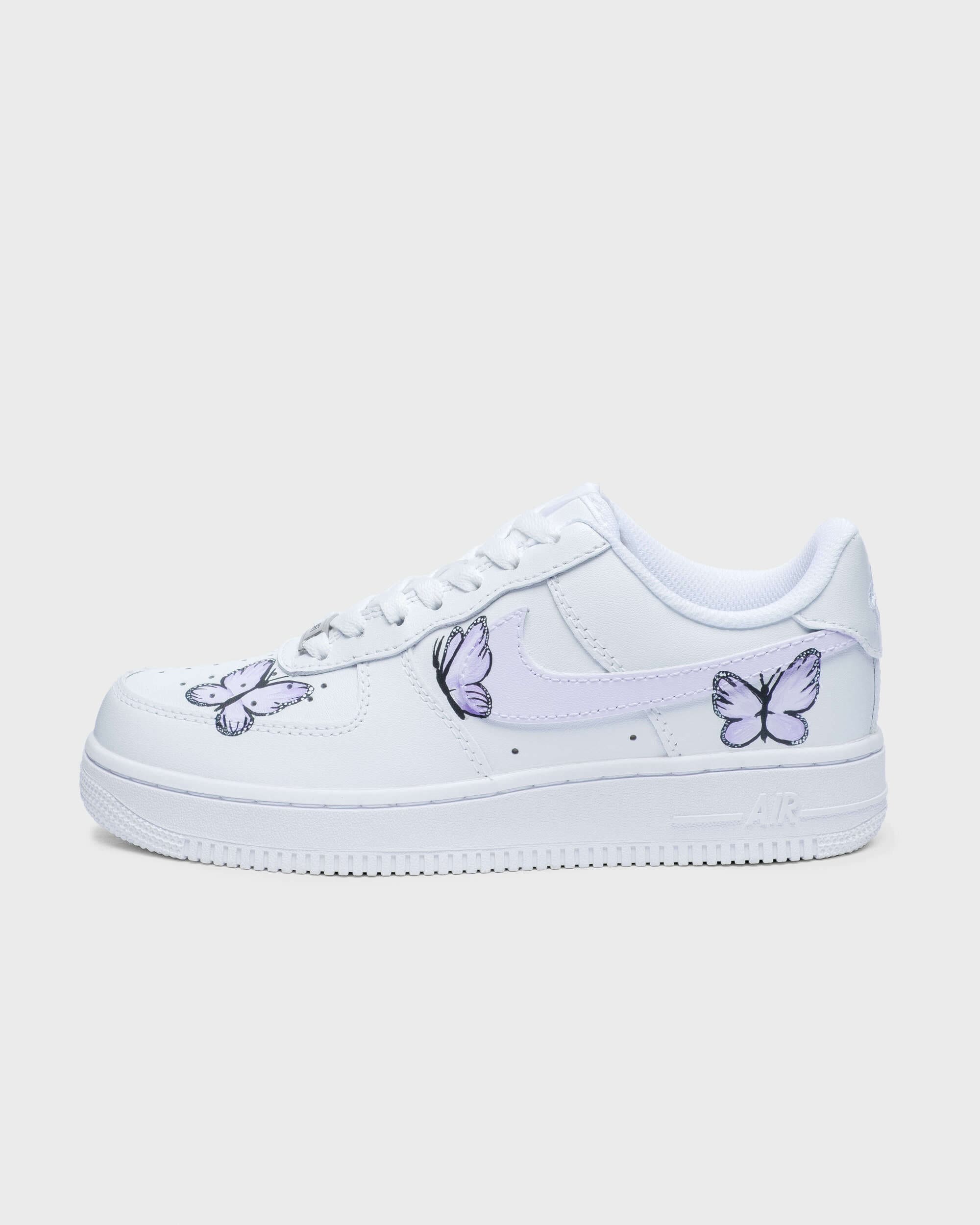 Side profile of hand-painted custom Air Force 1 sneaker with purple butterfly artwork on white leather. 