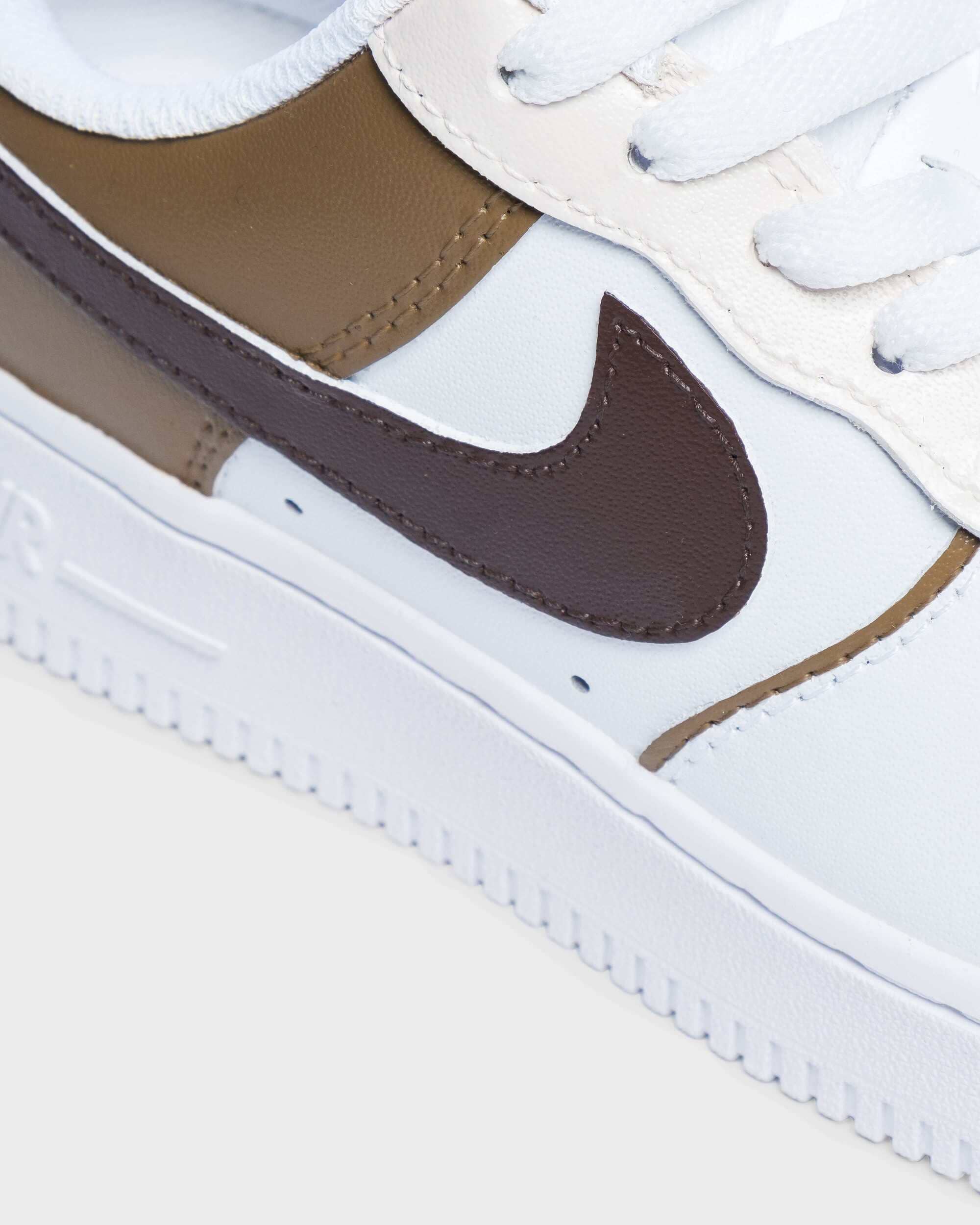 Close-up view of custom Air Force 1 with brown and tan Nike Swoosh design, handcrafted with premium materials.