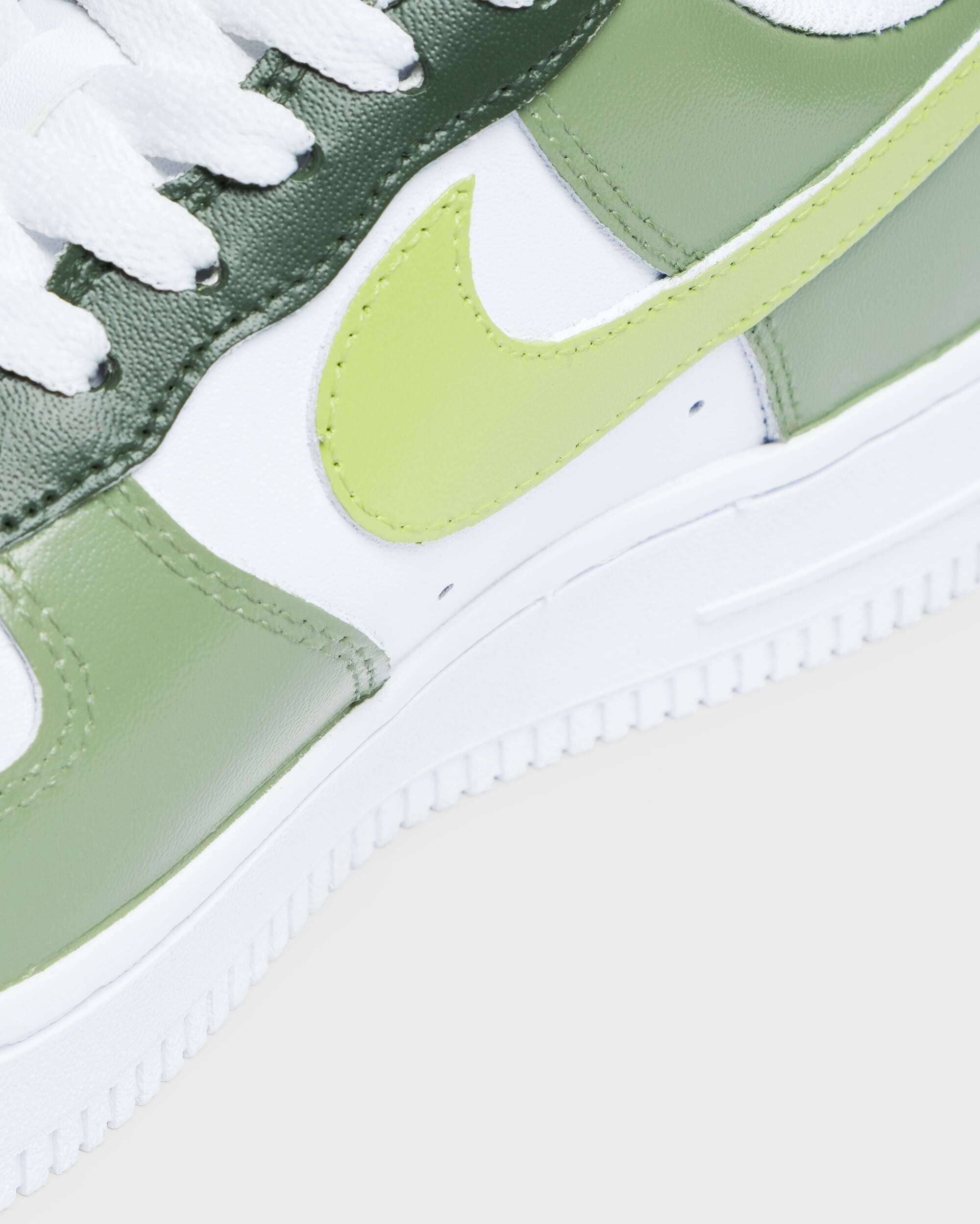 Close-up of Nike Air Force 1 sneaker in green with lime swoosh, highlighting leather texture.