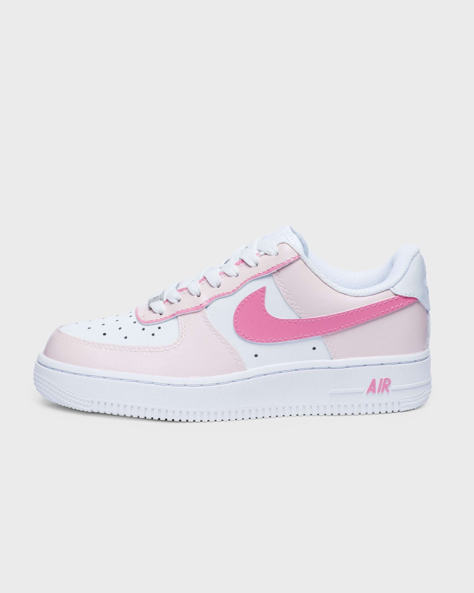 Side profile of custom Air Force 1 sneaker with a bold pink swoosh and soft pink overlays on a white leather base, perfect for a stylish and personalized look.