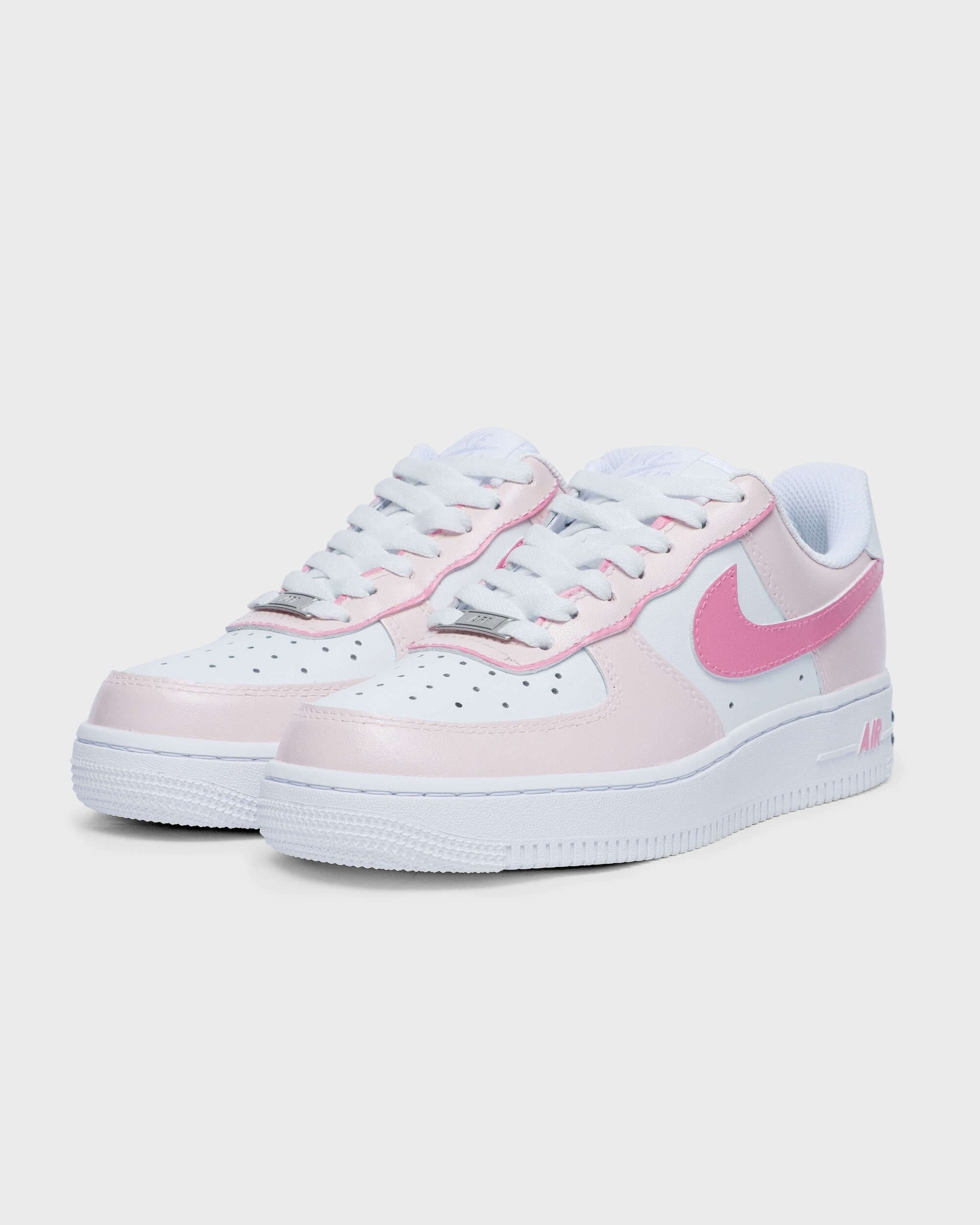 Custom Air Force 1 sneakers with pink swoosh and pastel pink detailing on the side, showcasing a trendy, personalized design.