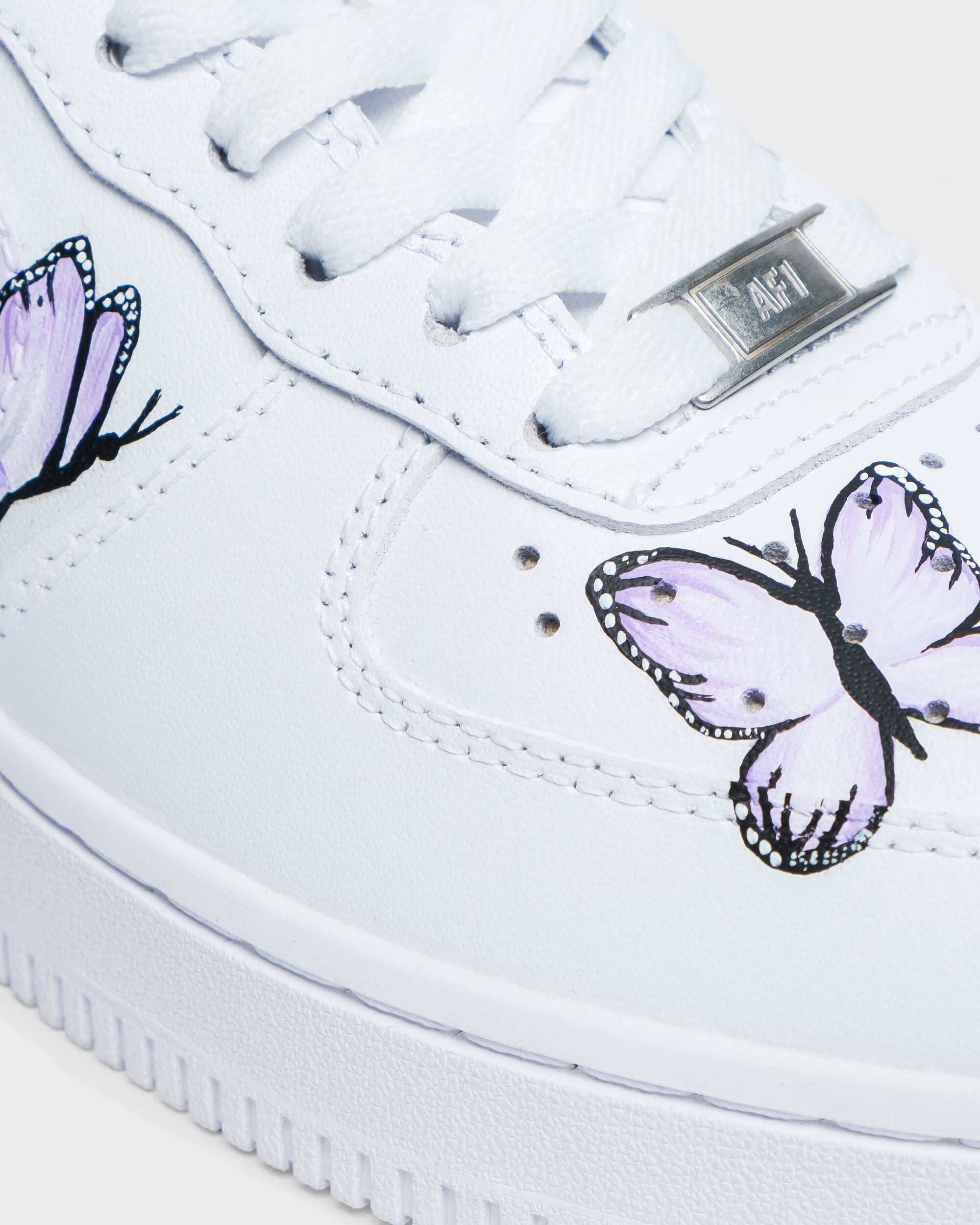 lose-up of hand-painted custom Air Force 1 sneaker with delicate purple butterfly design