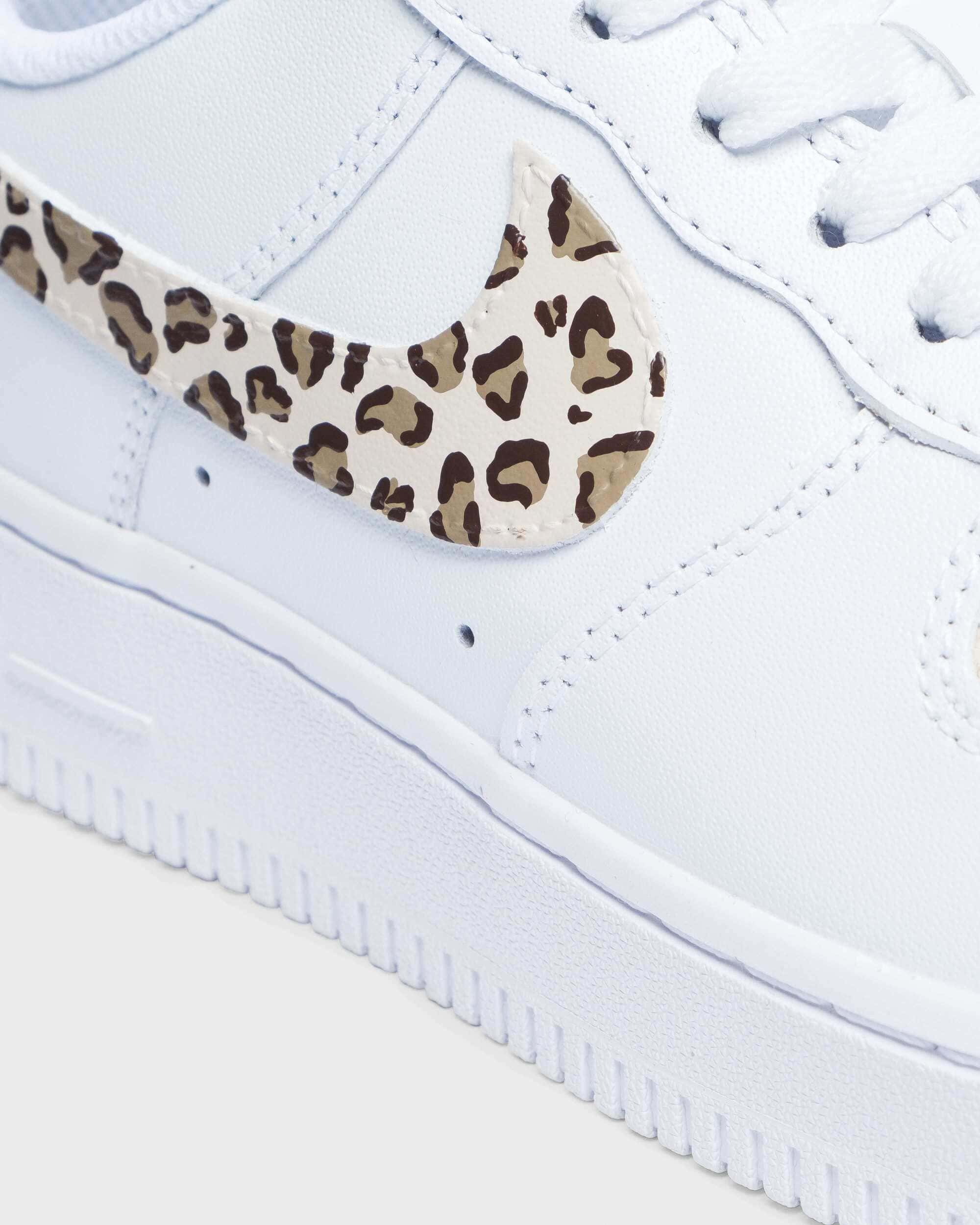 Close-up of custom Air Force 1 sneaker with a leopard print swoosh on a white leather base, showcasing the unique and bold animal print design for a personalized touch.