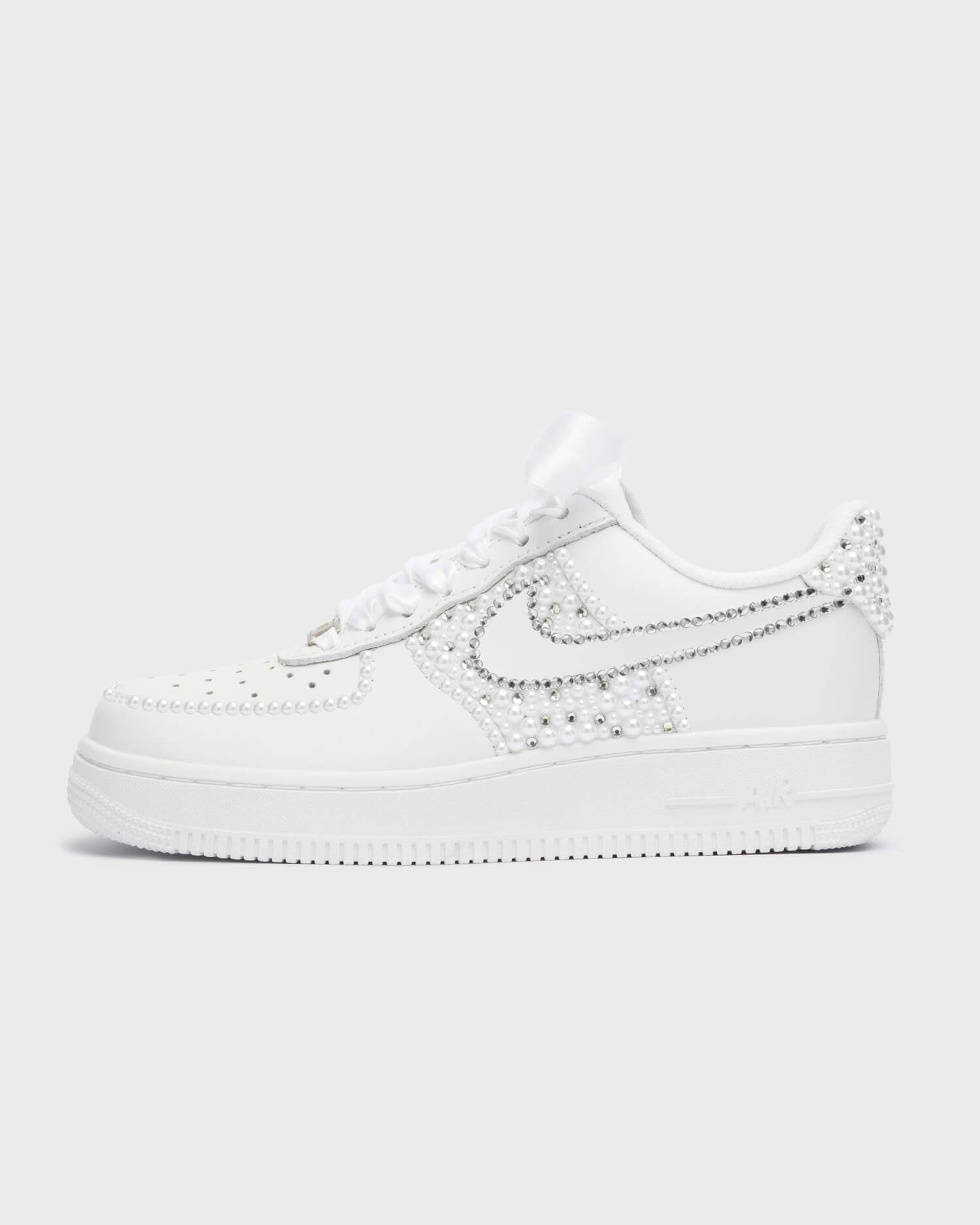 Custom white Nike Air Force 1 wedding sneakers with pearl and rhinestone design on the swoosh and heel, handmade bridal shoes with satin laces.