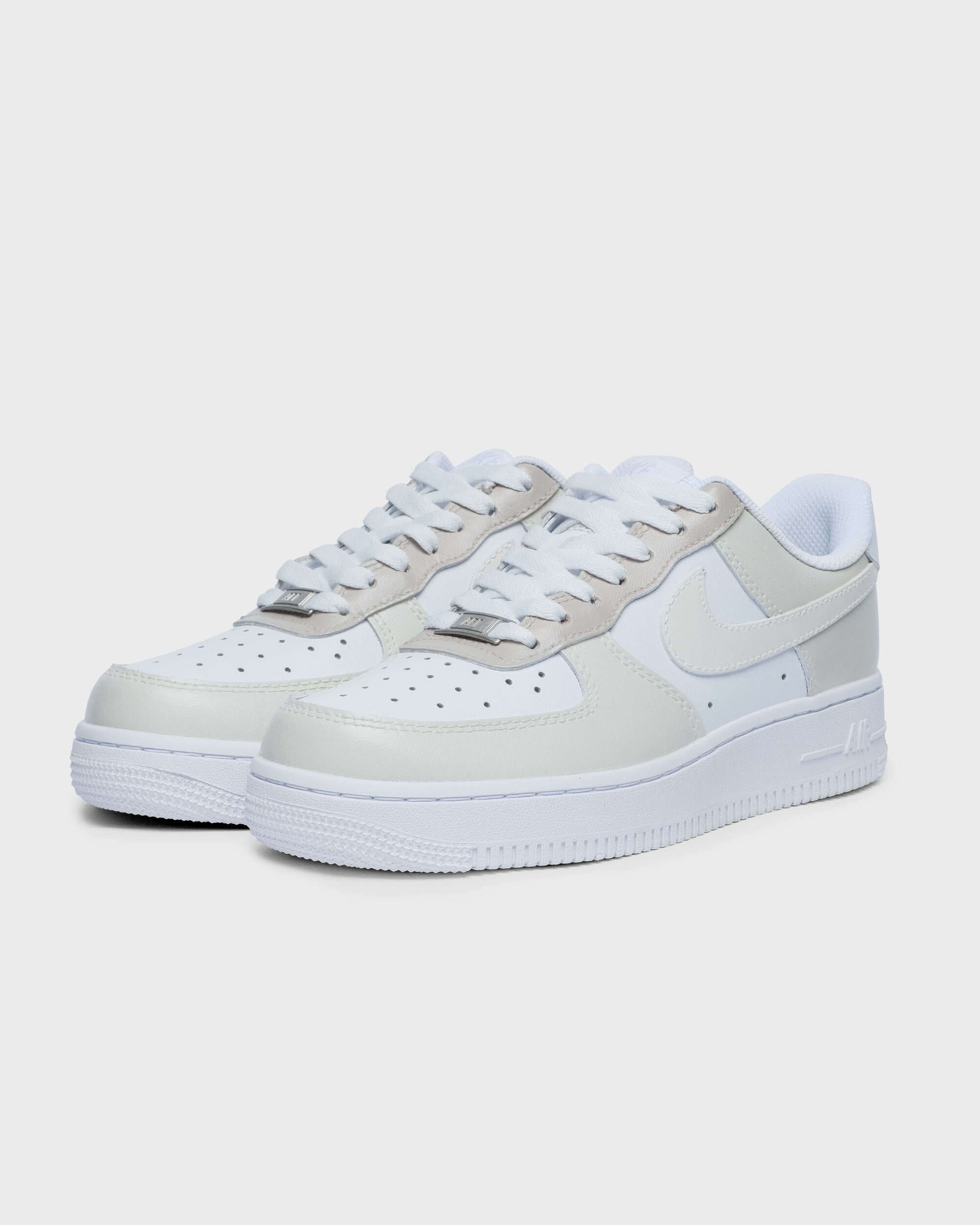 Side view of custom beige and white Air Force 1 sneakers with hand-painted swoosh, offering a clean, neutral design perfect for everyday wear.