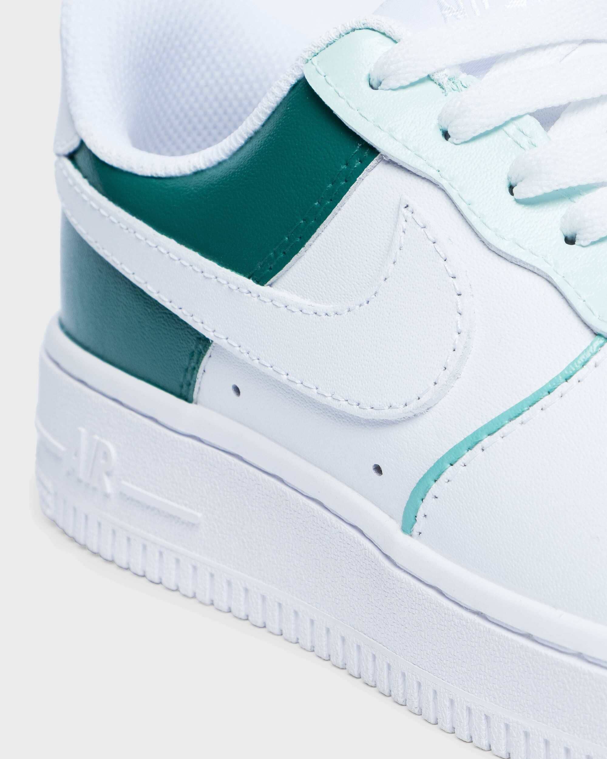 Close-up of custom Air Force 1 sneakers with a white and teal green color combination, hand-painted for a unique style."