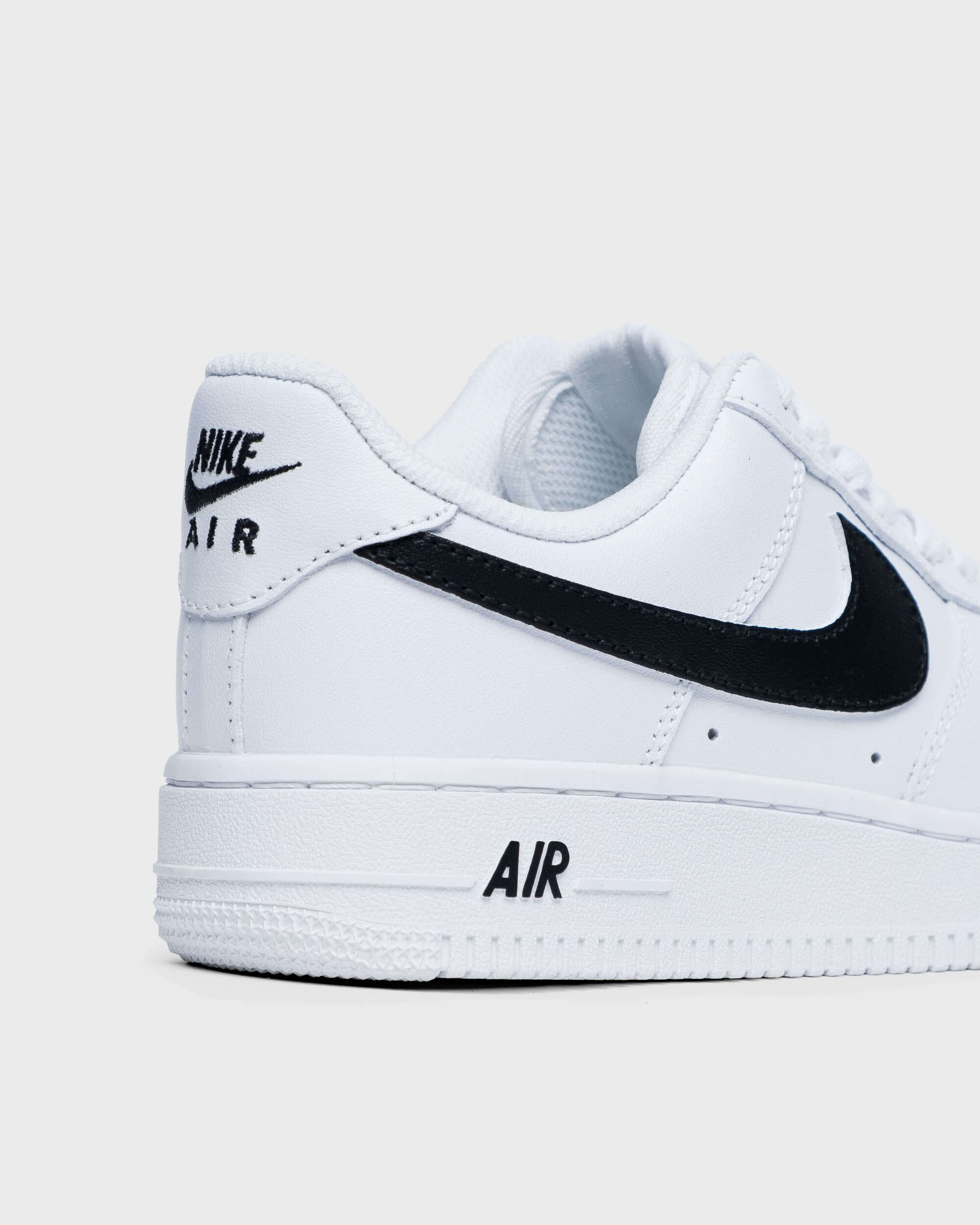 Custom Nike Air Force 1 sneakers with a classic black swoosh, close-up view of the side and heel logo detail for personalized style.