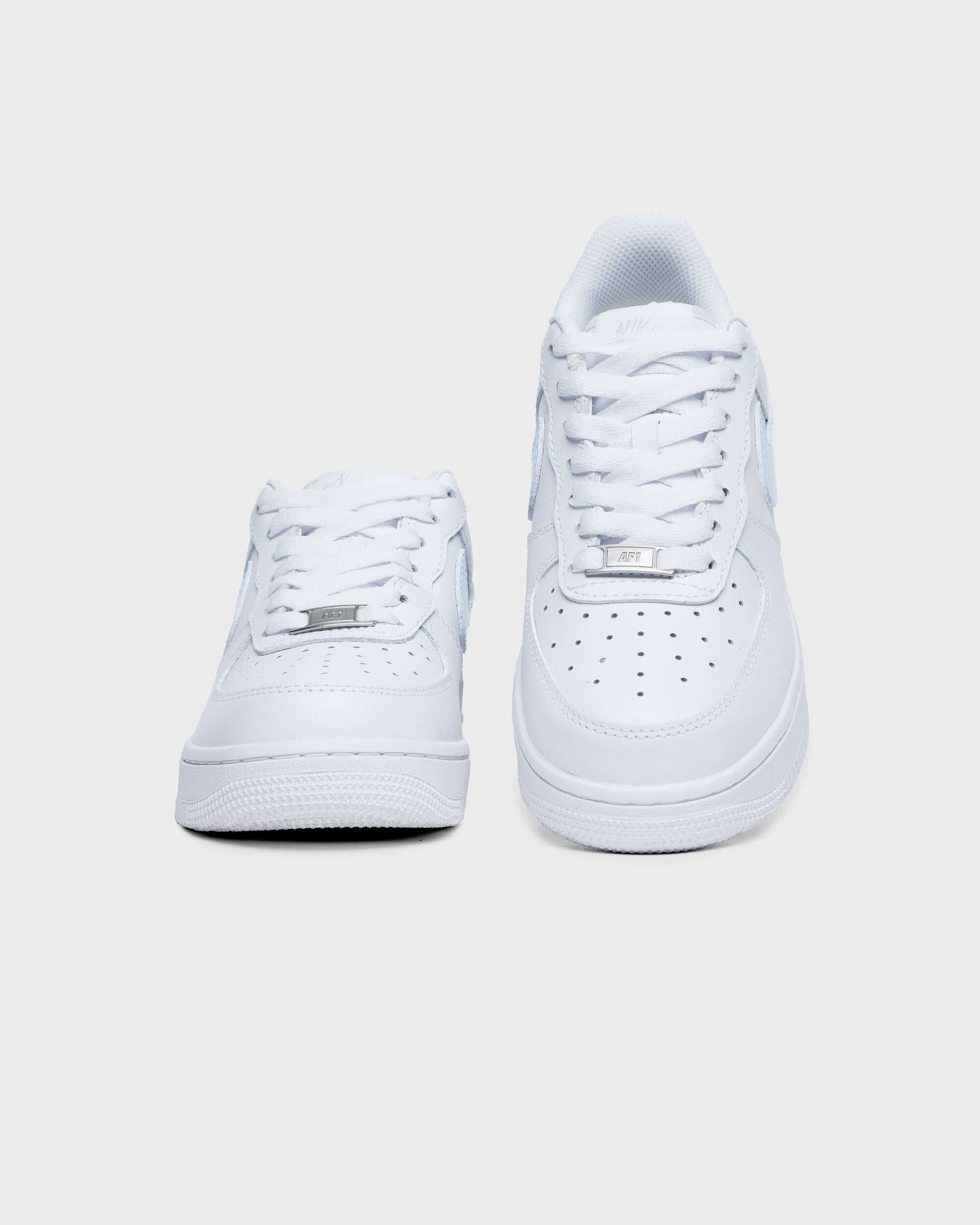 Front view of custom white Air Force 1 sneakers with subtle blue accents, white laces, and perforated toe box, showcasing a clean, minimalist aesthetic.