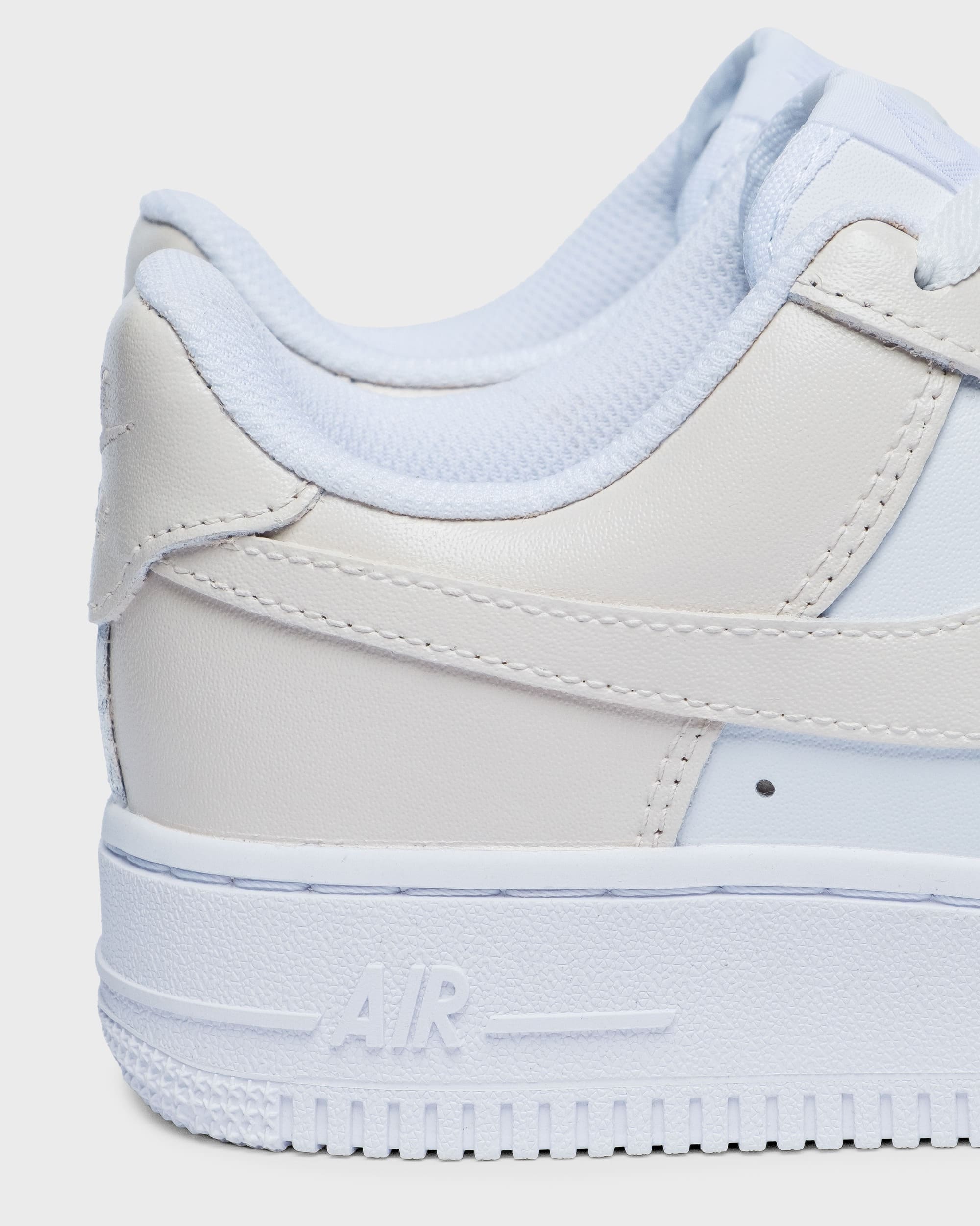 Close-up of custom Air Force 1 sneaker with a subtle cream tone, featuring a minimalist and clean design