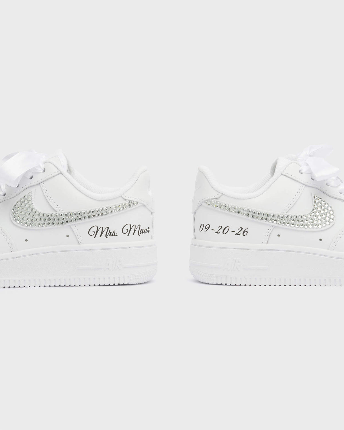 Personalized white Air Force 1 wedding sneakers with rhinestone swoosh, 'Mrs. Maur' embroidery, and custom wedding date '09-20-26'. Handcrafted bridal shoes with satin laces for a special occasion.