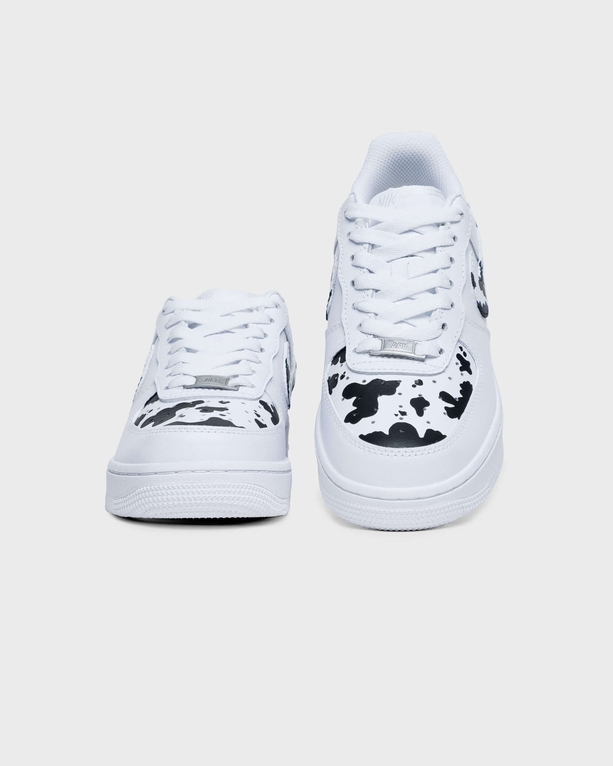 Front view of custom Air Force 1 sneakers featuring a bold cow print design, showcasing hand-painted details.