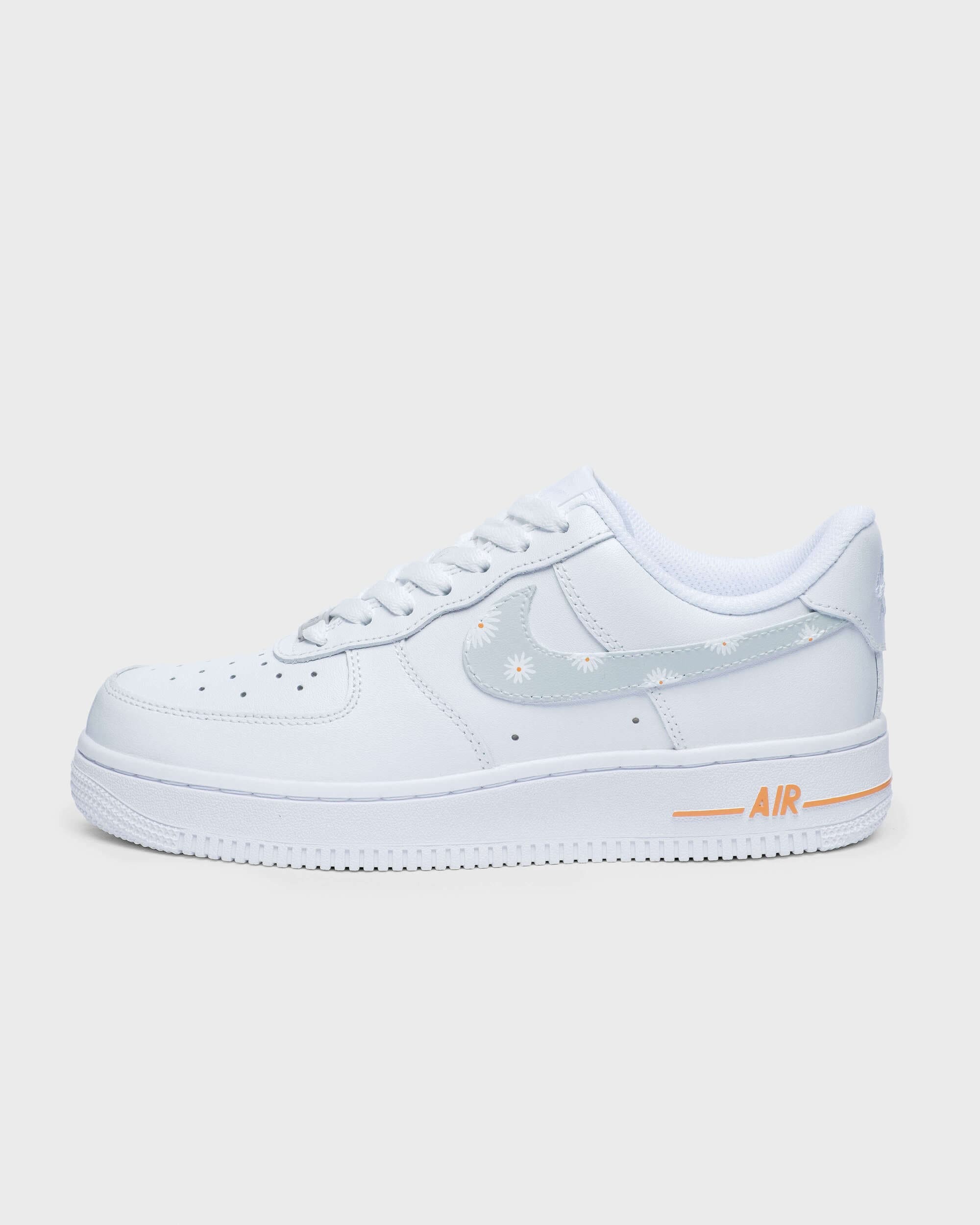 Side profile of custom Air Force 1 sneaker with delicate hand-painted flower pattern on a light gray Swoosh.