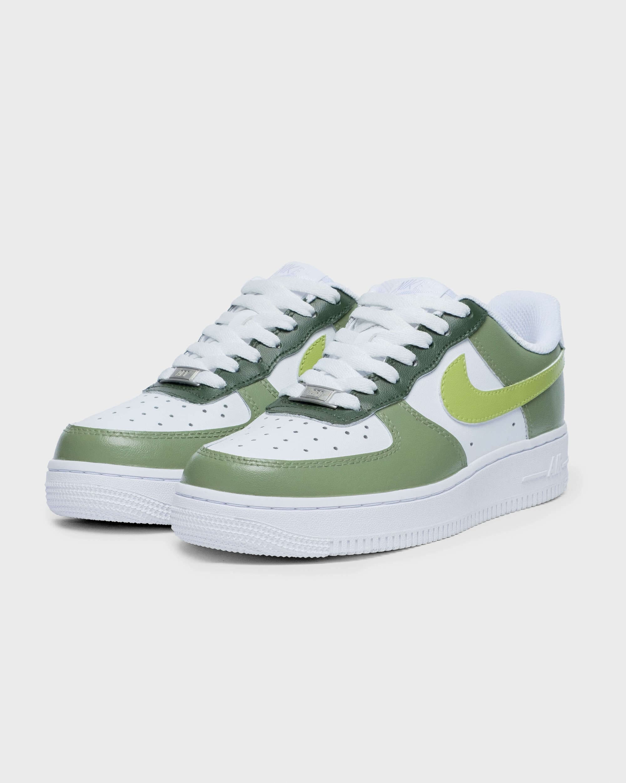 Side angle of Nike Air Force 1 sneakers in green with lime swoosh on white background.