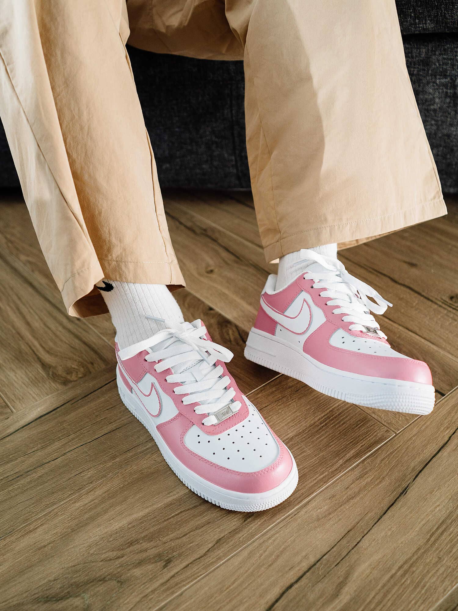 Pink and white custom Air Force 1 sneakers worn with beige pants and white socks – displaying a casual outfit paired with the custom sneakers.