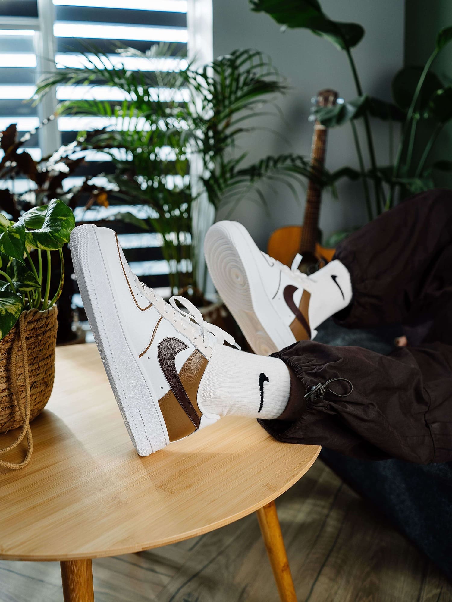 Custom Air Force 1 sneakers with brown and tan Swoosh design, showcased in a relaxed setting for a stylish, casual vibe.