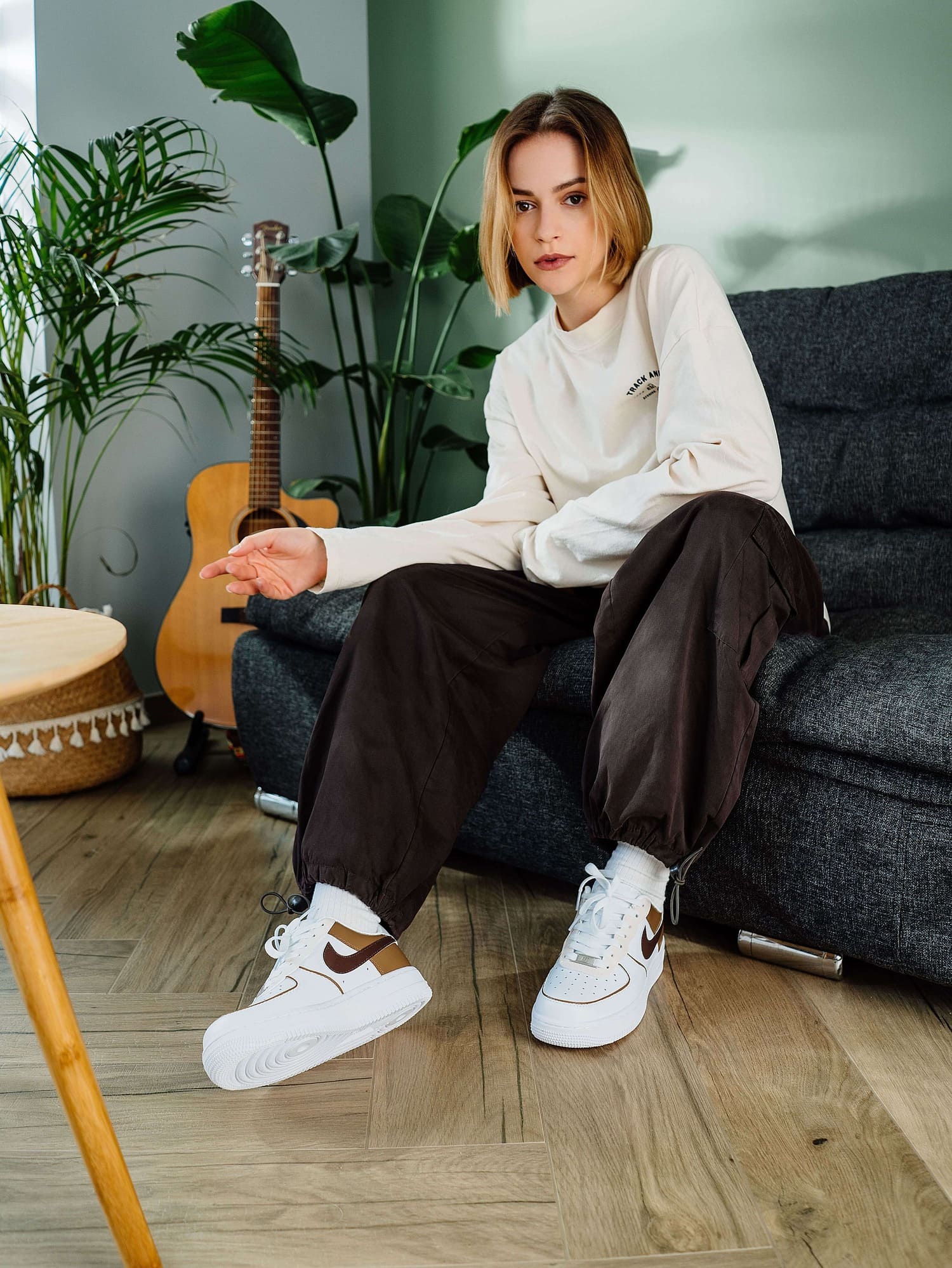 Model wearing custom Air Force 1 sneakers with brown and tan Swoosh, a perfect match for casual street style.