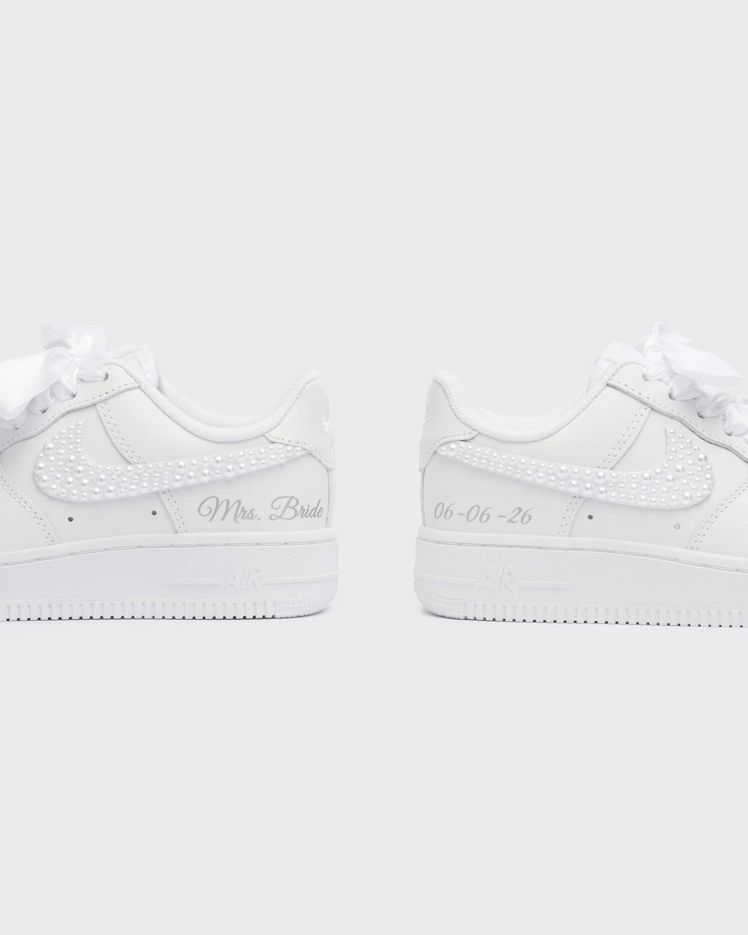 Personalized white Air Force 1 wedding sneakers with pearl swoosh, 'Mrs. Bride' embroidery, and custom wedding date '06-06-26'. Elegant handcrafted bridal sneakers for a stylish wedding day.