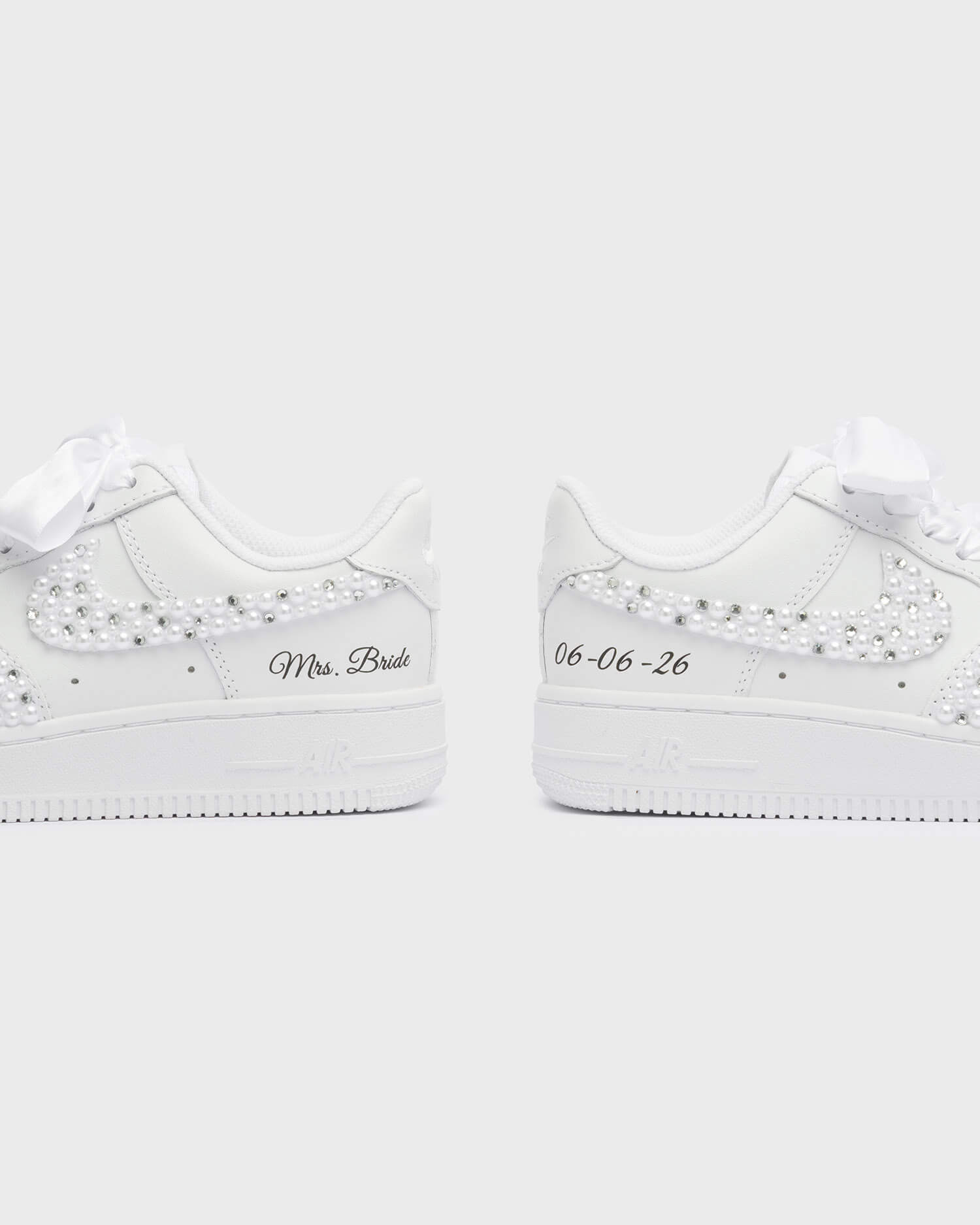 Personalized white Air Force 1 wedding sneakers with pearl embellishments, 'Mrs. Bride' embroidery, and custom wedding date '02-02-25'. Elegant handcrafted bridal sneakers for a unique wedding style.